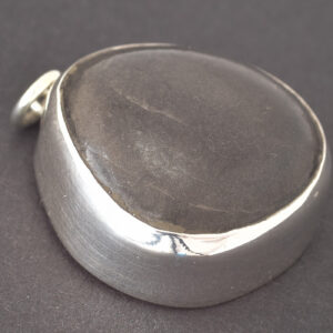 Handgefertigter Kiesel-Anhänger „Flüstern der Wellen“ – schwarzer Strandkiesel mit 925er Sterlingsilberfassung, maritimer Schmuck