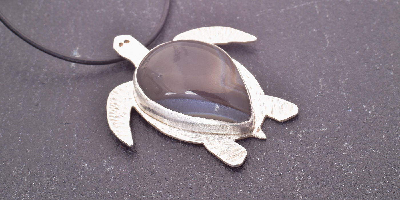 Schildkröten Anhänger Wächterin der Tiefe – handgefertigter Anhänger aus Silber mit gebändertem Onyx