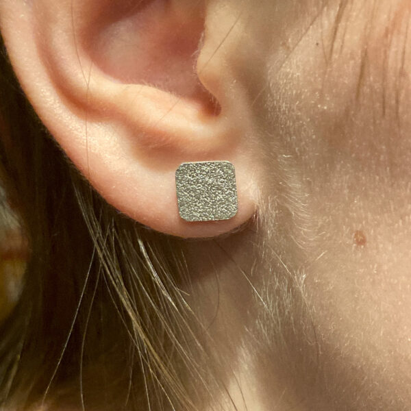 Paar Ohrstecker Wüstenwind aus recyceltem Silber mit sandiger Oberfläche getragen parallel